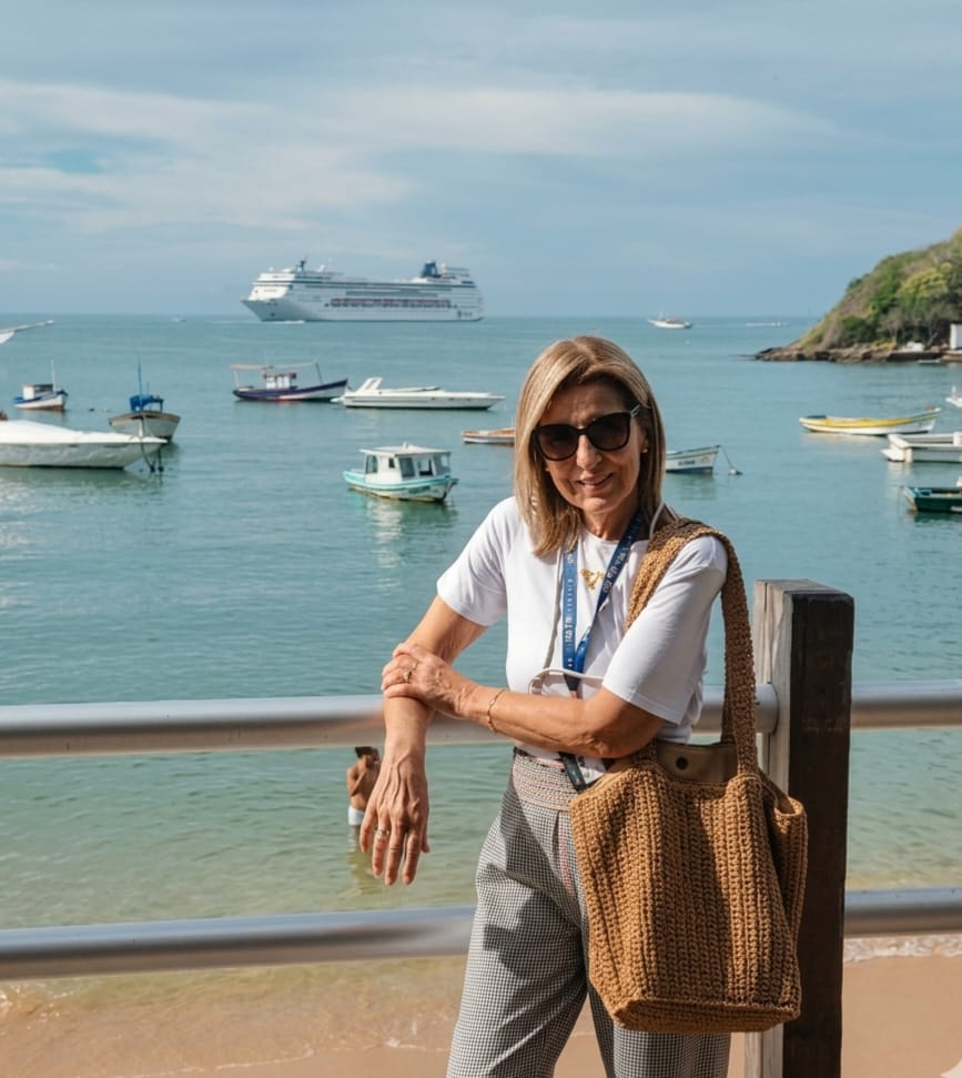 Marzi Medina, fundadora da HM Tur Viagens, em Santos com navio ao fundo